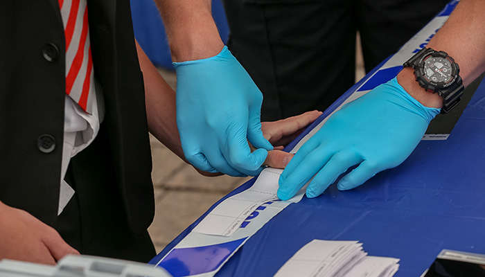 A person wearing forensic gloves doing a demonstration